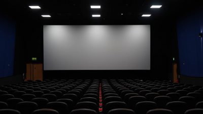 Un cine vacío con varios pasillos de cómodas butacas